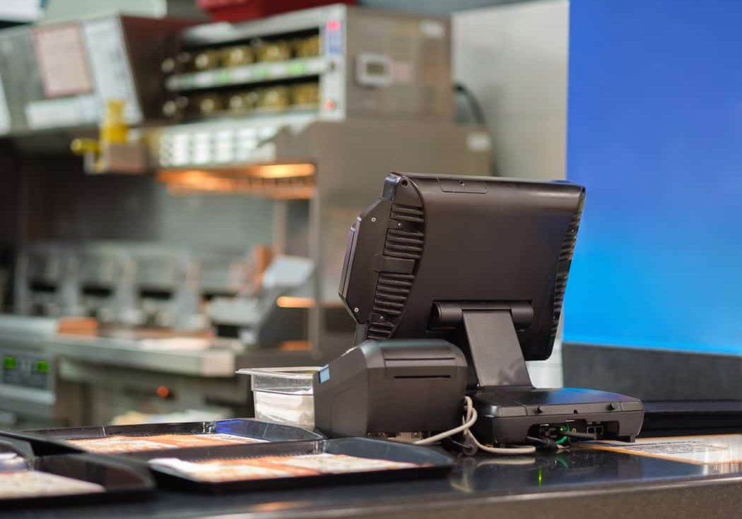 Cash and order desk and kitchen equipment on back in fast food restaurant