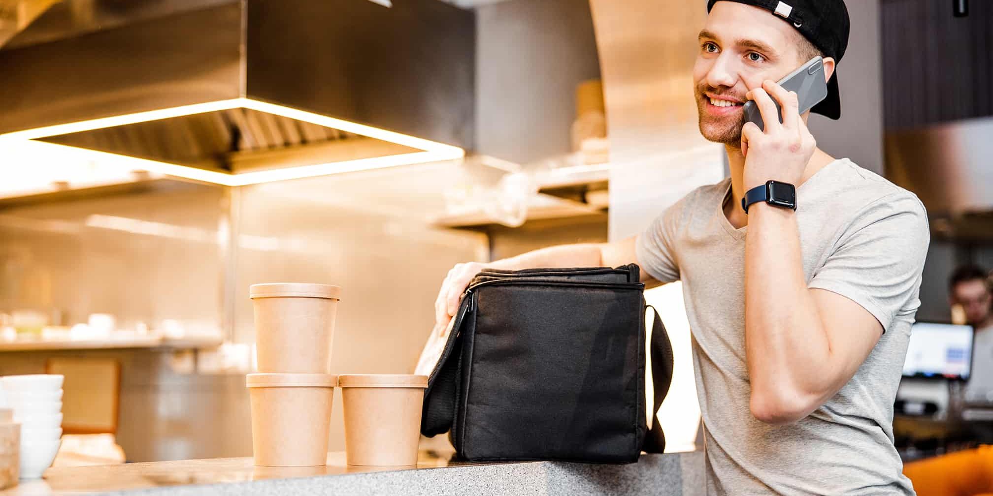 Handsome guy carrying the bag with take away food and beverages stock photo